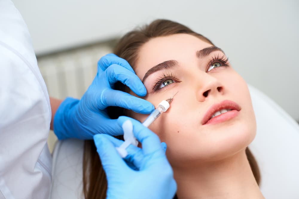 Injector administering under-eye dermal fillers to rejuvenate tear troughs and reduce dark circles at Eastside Aesthetics & Wellness in Issaquah, WA