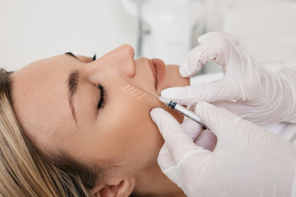 Injector administering dermal fillers to smooth smile lines and restore youthful volume at Eastside Aesthetics & Wellness in Issaquah, WA.