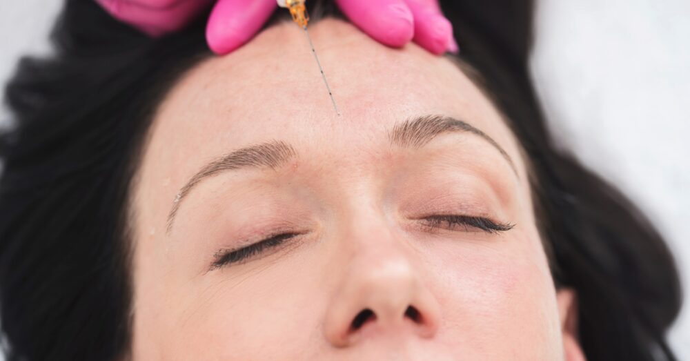 Provider administering a Juvederm dermal filler injection to a female’'s forehead