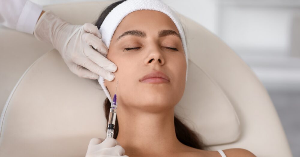 Aesthetician performing a Juvederm filler treatment on a relaxed female