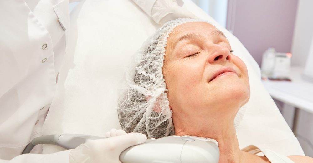 Woman receiving non-surgical skin tightening treatment on her neck